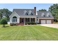 Charming two-story brick home with well-manicured lawn and dormer windows at 2709 Les Paul Ln, Apex, NC 27539