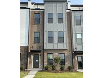 Charming townhome with brick and gray facade, modern windows, and well-maintained landscaping at 2908 Kempthorne Rd # 53, Cary, NC 27519