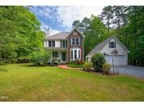 Charming two-story home featuring brick accents, a welcoming front porch, and a detached garage at 3137 Falling Cedars Dr, Chapel Hill, NC 27516