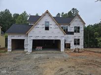 New construction home featuring a two-car garage and partially finished facade in a wooded location at 3905 Cedar Knolls Dr, Youngsville, NC 27596