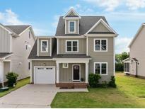 Charming two-story home with a landscaped front yard and a two-car garage and inviting front porch at 418 Wyndham Drive, Chapel Hill, NC 27516