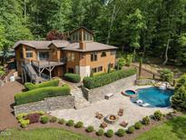 Stunning home with private pool, hot tub, and beautiful landscaping surrounded by lush greenery at 4312 Mystic Ln, Hillsborough, NC 27278