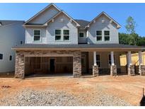 Craftsman-style home featuring stone accents and a welcoming covered porch, blending elegance with modern design at 444 Golden Dragonfly St, Wake Forest, NC 27587