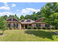 Charming brick home featuring a lush green lawn and mature landscaping at 46 Spring Haven Ln, Willow Springs, NC 27592