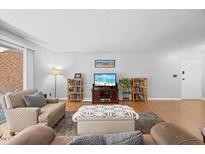 Cozy living room with a decorative ottoman, media center, and views from a large sliding glass door at 4709 Edwards Mill Rd # H, Raleigh, NC 27612