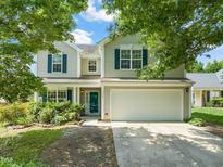 Two-story home with a two-car garage, blue shutters, and landscaped front yard at 5312 Suntan Lake Dr, Raleigh, NC 27610