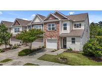 Charming townhome featuring a stone accent wall, attached garage, and well-maintained landscaping at 5320 Jessip St, Morrisville, NC 27560