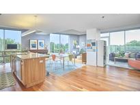 Bright, open-concept living space with hardwood floors and modern furniture, plus island with seating at 601 W Rosemary St # 416, Chapel Hill, NC 27516