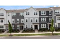 Charming townhome exterior featuring a mix of stone accents and neutral colored siding and manicured landscaping at 6415 Mentor Pl, Raleigh, NC 27616