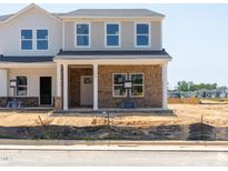 Charming two-story home with brick facade, covered porch, and neutral color palette at 719 Chandler Stone Dr, Zebulon, NC 27597
