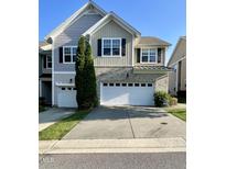 Charming townhome featuring a two-car garage, neutral siding, and manicured lawn at 7241 Terregles Dr, Raleigh, NC 27617