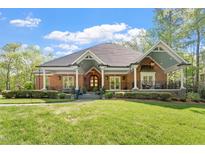 Stunning brick home with a covered front porch, lush lawn, and beautiful landscaping at 801 Pinehurst Dr, Chapel Hill, NC 27517