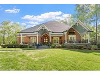 Charming brick home featuring a welcoming front porch with beautiful columns and manicured landscaping at 801 Pinehurst Dr, Chapel Hill, NC 27517