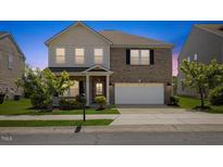 Charming two-story home featuring a brick facade, two-car garage, and well-maintained landscaping at 833 Ember Dr, Durham, NC 27703