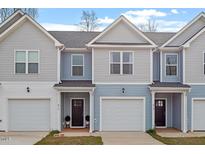 Charming townhome exteriors featuring light blue and grey siding, attached garages, and inviting front doors at 882 John St, Clayton, NC 27520