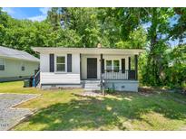 Charming single-story home featuring a welcoming front porch and tidy landscaping at 104 Archdale Dr, Durham, NC 27707