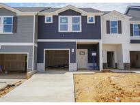 View of new construction townhomes with attached garages and unfinished landscaping at 1052 Winding Spring Drive, Mebane, NC 27302