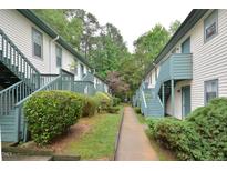 Apartment building exterior featuring painted siding, green trim, and stairs to the second level at 107 Ashley Forest Rd # B, Chapel Hill, NC 27514