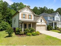 Charming two-story home with a well-manicured lawn, inviting front porch, and attached two-car garage at 111 Chapel Run Way, Chapel Hill, NC 27517