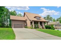 Charming two-story home showcasing a well-manicured lawn and a spacious driveway leading to an attached garage at 111 Streamside Dr, Sanford, NC 27330