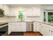 Bright kitchen featuring white cabinets, stainless steel appliances, and granite countertops at 114 Oxpens Rd, Cary, NC 27513