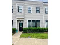 Charming townhome with gray siding, black trim, manicured lawn, and sidewalk at 142 Philips Sq, Chapel Hill, NC 27516