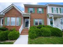 Charming brick townhome with green shutters and manicured front yard landscaping at 1806 Stroll Cir, Fuquay Varina, NC 27526