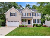Charming two-story home with a well-manicured lawn, blue shutters, and a welcoming front porch at 201 Forbes Rd, Wake Forest, NC 27587