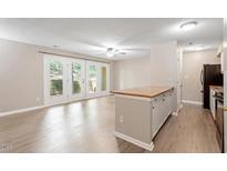 Bright living room features hardwood floors, lots of natural light, and breakfast bar to kitchen at 2010 Quaker Lndg # 102, Raleigh, NC 27603
