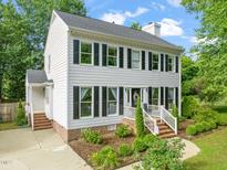 Charming two-story home with white siding, black shutters, brick foundation and well-manicured landscaping at 21 Cedar Hill Dr, Durham, NC 27713