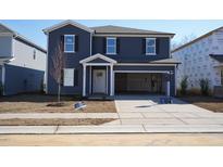 Charming two-story home with blue siding, open garage, and landscaped front yard at 2106 Cherry Creek Road Rd, Haw River, NC 27258