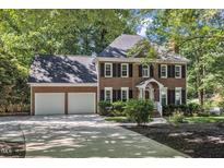 Charming brick home featuring an attached two car garage and well-manicured landscaping at 2125 Oakcrest Ct, Raleigh, NC 27612