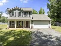 Charming two-story home featuring a welcoming front porch, a two-car garage, and a well-maintained lawn at 218 Mason Rd, Durham, NC 27712