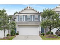 Charming two-story townhome with a two-car garage, gray siding, blue shutters, and a well-manicured lawn at 222 Explorer Dr # 271, Morrisville, NC 27560