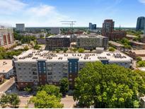 A beautiful aerial view of a modern apartment building surrounded by mature trees and a vibrant cityscape at 222 Glenwood Ave # 714, Raleigh, NC 27603