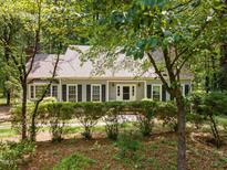 Charming single-story home featuring a well-maintained yard, mature trees, and classic architectural details at 24 Sunrise Pl, Durham, NC 27705