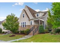 Inviting two-story home with a beautifully landscaped front yard and charming architectural details at 2837 Milano Ave, Apex, NC 27502