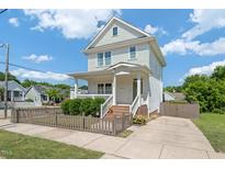 Charming two-story home with a covered porch, landscaped yard, and inviting curb appeal on a sunny day at 309 S Haywood St St, Raleigh, NC 27601