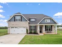Charming single-Gathering home with a well-manicured lawn and attached two-car garage at 337 Brinkley Cir, Mebane, NC 27302