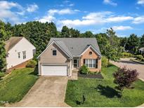 Charming home with manicured lawn, attached garage, and brick and siding exterior at 3400 Secretariat Way, Raleigh, NC 27614