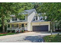 Charming two-story home with a welcoming front porch and attached two-car garage at 353 Spearhead Pl, Clayton, NC 27520