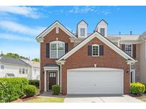 Charming brick townhome featuring a two-car garage and manicured front yard at 401 Dyersville Dr, Morrisville, NC 27560