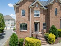 Inviting brick home featuring landscaped front yard and classic architectural details and a black front door at 441 Heritage Village Ln, Apex, NC 27502