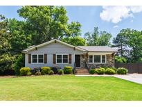Charming single-story home with a well-maintained lawn, stone accents, and inviting curb appeal at 4906 Lakemont Dr, Raleigh, NC 27609