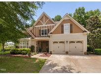 Charming two-story home featuring a manicured lawn, a two-car garage, and a combination of stone and wood facade at 60 Morning Mist Dr, Garner, NC 27529