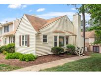Charming townhome with light yellow siding, brown roof, and landscaped front yard at 6540 English Oaks Dr, Raleigh, NC 27615