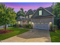 Charming two-story home featuring a well-manicured lawn and a two-car garage on a tree-lined lot at 68 Tanners Way, Clayton, NC 27527