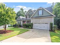 Charming two-story home featuring a well-manicured lawn, two car garage and inviting curb appeal in a landscaped yard at 68 Tanners Way, Clayton, NC 27527