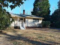 Quaint one-story home with a welcoming front porch and mature shade trees at 912 Dixie Trl, Raleigh, NC 27607