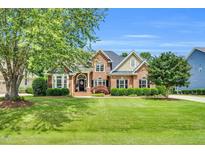 Charming two-story brick home with manicured lawn, mature trees, and classic curb appeal at 921 Riverwood Dr, Clayton, NC 27527